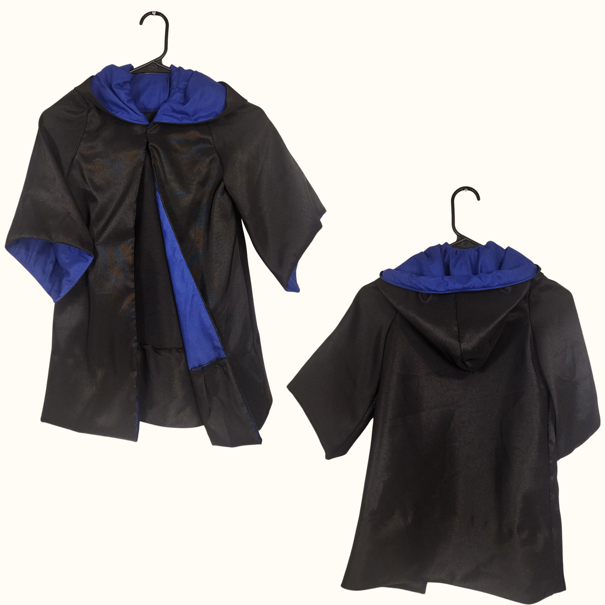 Two finished toddler wizard robes on hangers, black with blue contrast facing on the hood and down the front