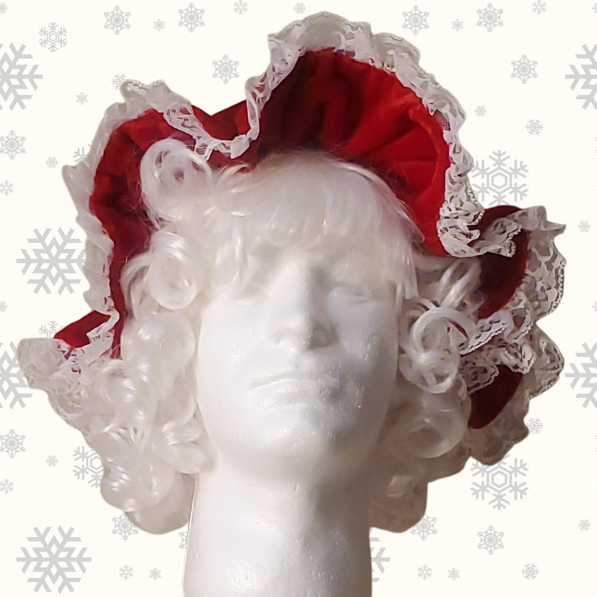 Front view of the red velvet Mrs Claus mop cap with white lace on a wig and foam head