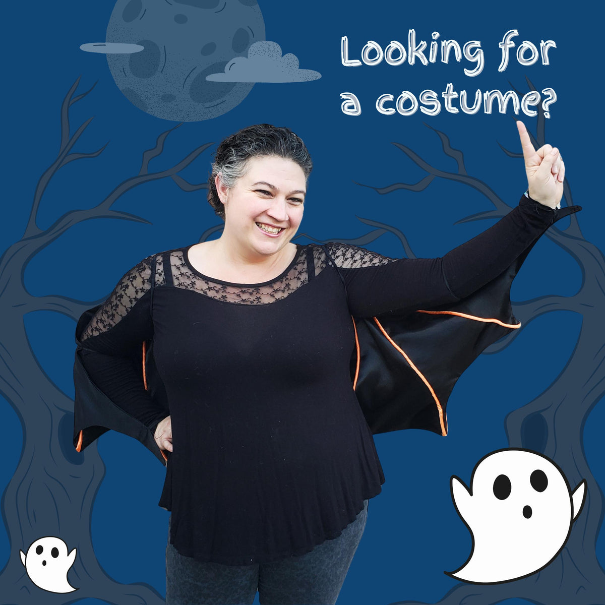 Smiling woman wearing a black bat wing cape with orange trim against a spooky blue Halloween background