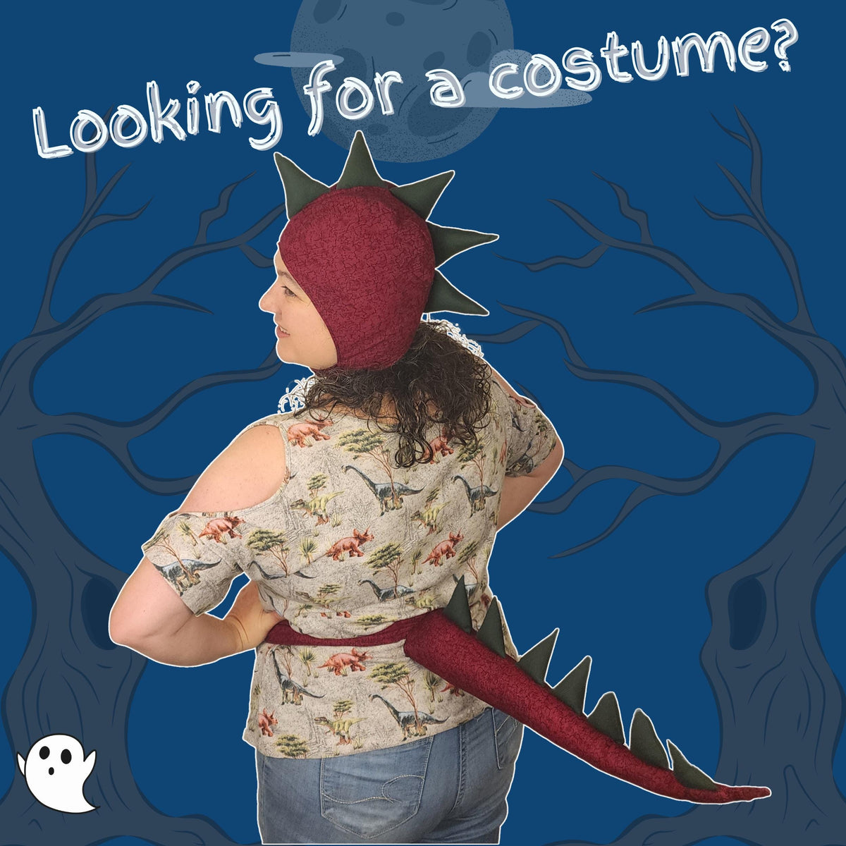 Back view of a woman in the red dinosaur hood and spiked tail on a spooky blue background