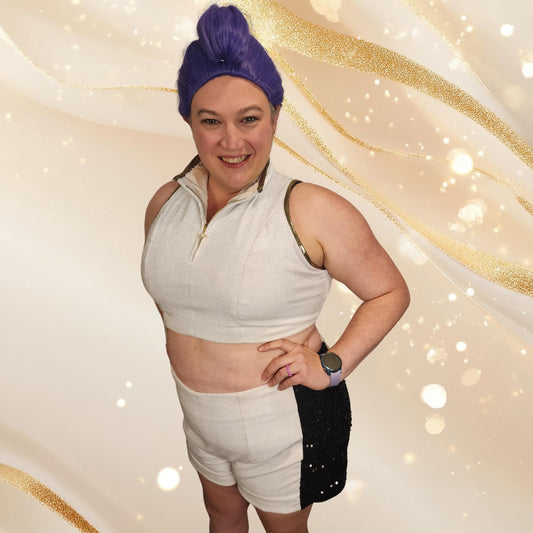 Woman in a purple wig wearing white cosplay shorts with black sequin side panels and a white crop top