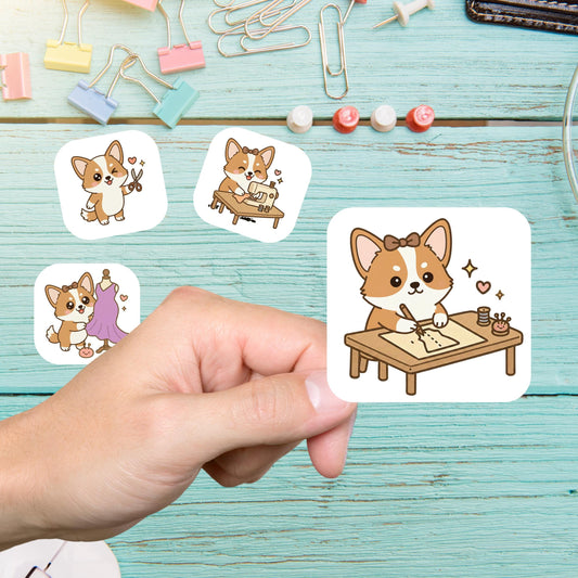 Hand holding a corgi sewing sticker of a corgi drafting at a table, with more corgi stickers on a teal desk