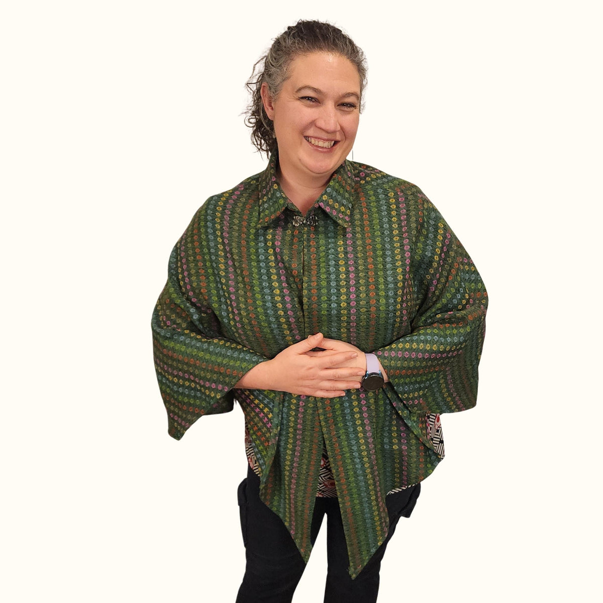 Woman wearing a green striped cozy cape with a collar