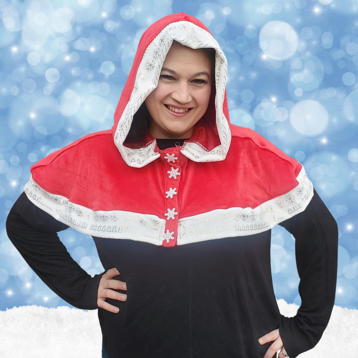 Woman in a red Mrs Claus capelet with white lace trim on a snowy background