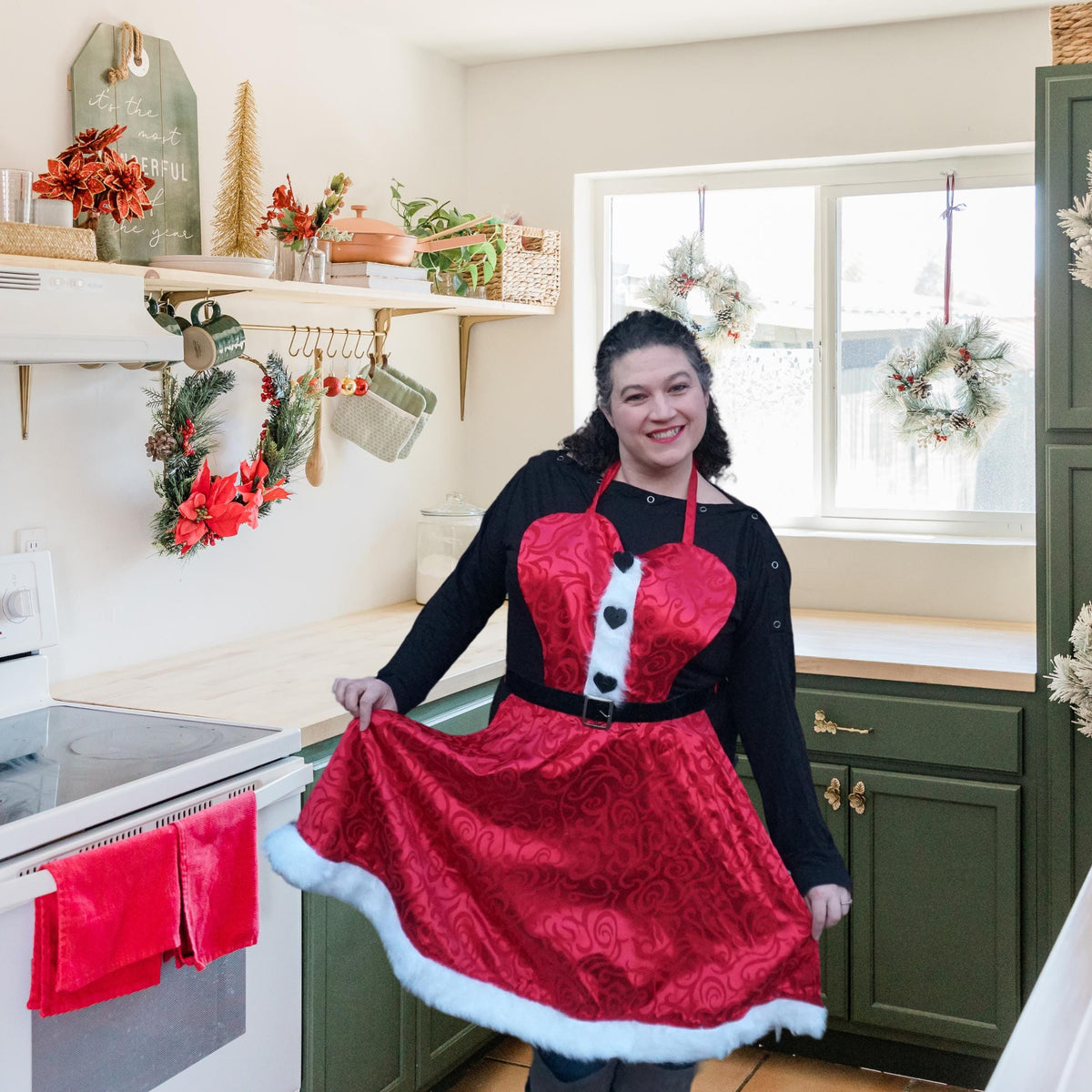 Woman in a red and black Mrs Claus apron with full skirt and white trim