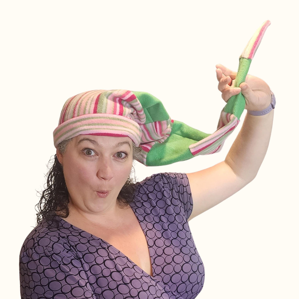 Woman in a long tail striped fleece elf hat holding the floppy tail up