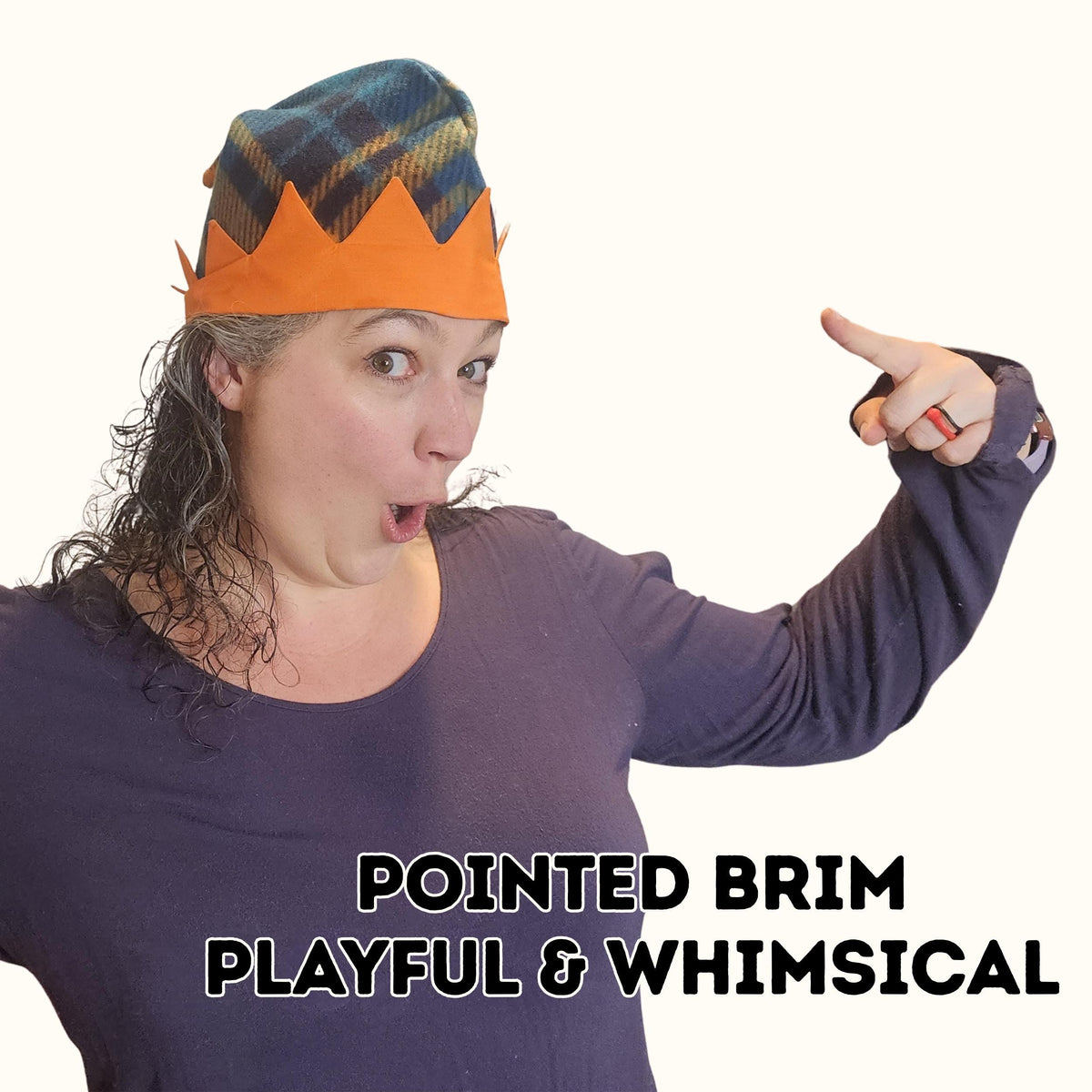 Woman pointing to her plaid pointed brim elf hat with an orange zigzag brim, playful and whimsical