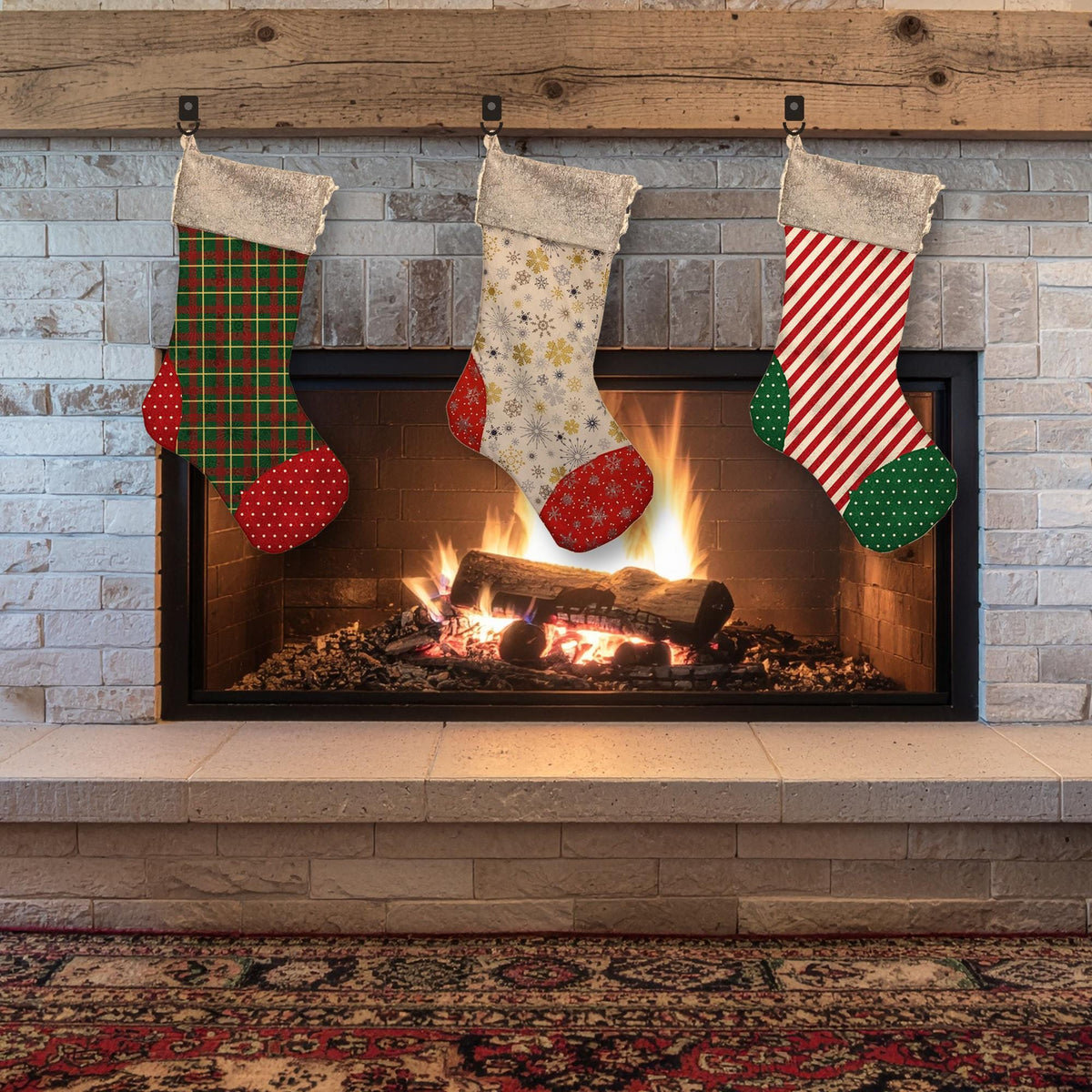 Three classic cuffed Christmas stockings in green plaid, gold snowflake and red stripe fabrics hanging on a stone fireplace mantel