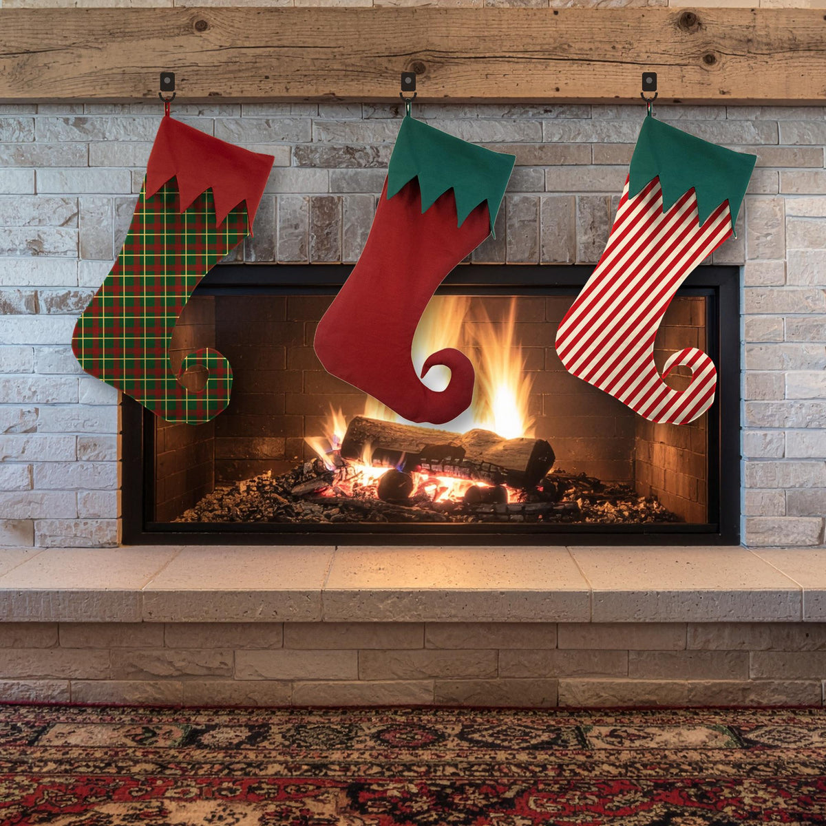 Three elf stockings with curled toes in green plaid, red and red stripe fabrics with green zigzag cuffs hanging over a fireplace