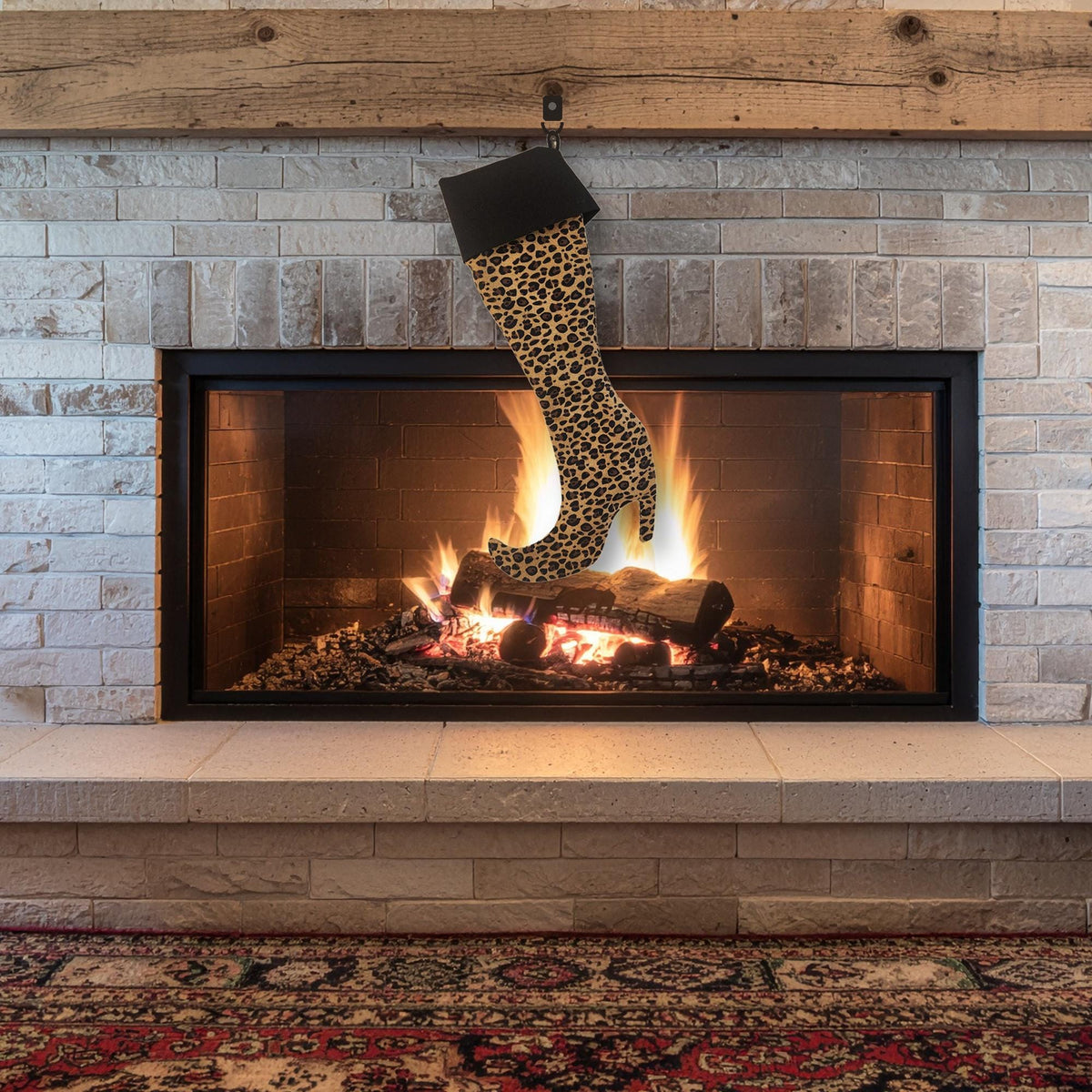 Leopard print high heel boot stocking with a black cuff hanging over a lit fireplace