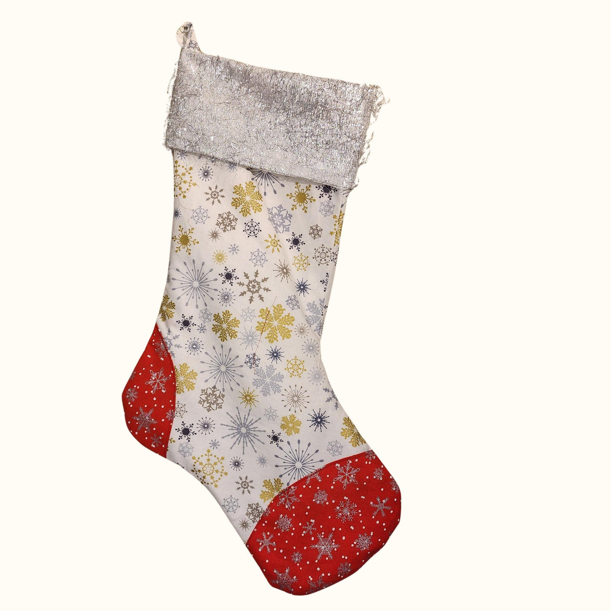 Finished classic Christmas stocking in white snowflake fabric with a sparkly silver cuff and red snowflake heel and toe